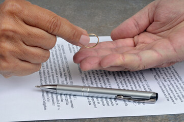 Concept de signature d'un acte de divorce avec la remise d'une alliance dans une main