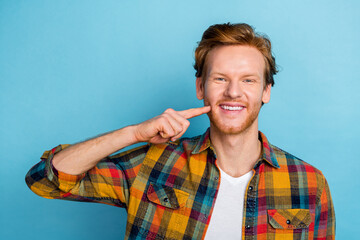 Closeup photo of young confident man showing how pretty self touching cheek isolated on blue color...