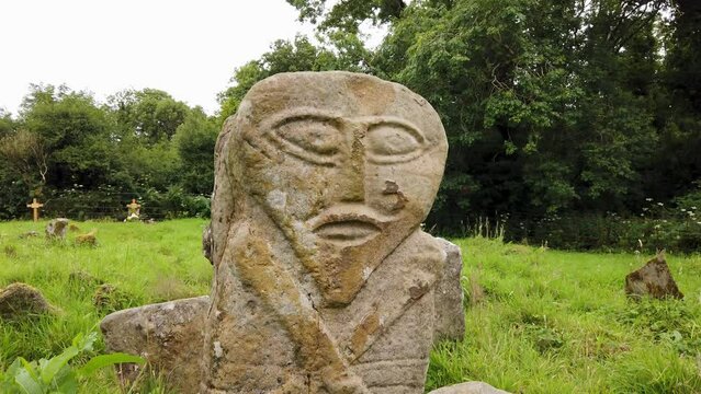 This is a bronze age stone carviing with two faces,called Janus, located In Caldragh Cemetery on Boa Island, Lower Lough Erne. Northern Ireland