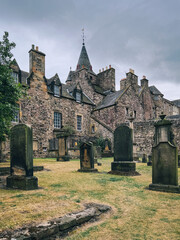 Edinburgh, Scotland, UK - July 2022: Gravestones on the graveyard behind Canongate Kirk on a cloudy afternoon
