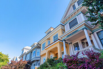 Fototapeta na wymiar Row of houses in a low angle view with victorian and mediterranean design at San Francisco, CA