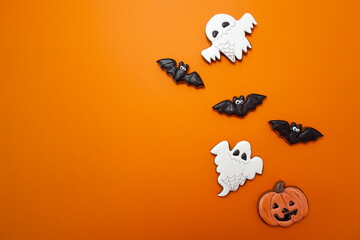 Gingerbread cookies for Halloween celebration are on an orange background