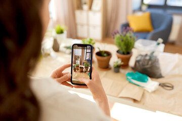 people, gardening and housework concept - close up of woman with smartphone photographing pot flowers at home