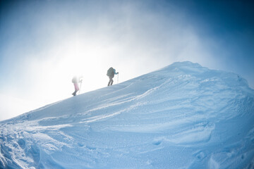 climbers climb to the top of the mountain in winter - obrazy, fototapety, plakaty