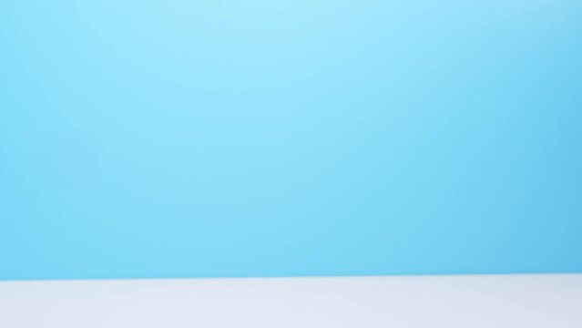 Close-up hand of caucasian people carry, send or give postal mail. Secure pickup service job from online shop store e-commerce with omni channel fast express post. Blue wall and white table. Zoom in