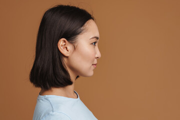 Young asian woman looking aside while posing in profile
