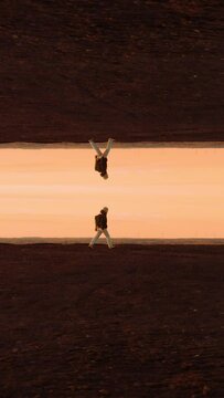 Vertical view of a man walking symmetrically at sunset