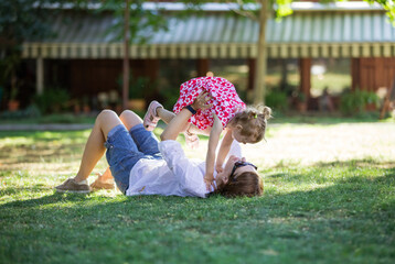 Mother and little girl having fun in summer park