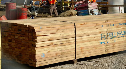 stack of lumber on job site of new building