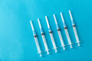 medicine, vaccination and healthcare concept - disposable syringes on blue background