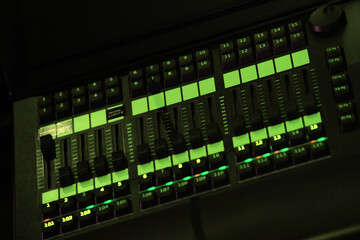 Audio mixer and microphone in blue color. Close-up of the Mixing console. mixing knobs.