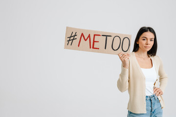 Young brunette woman holding placard with me too text