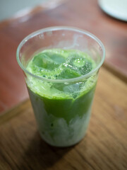 ice green tea matcha with milk on wooden table in cafe