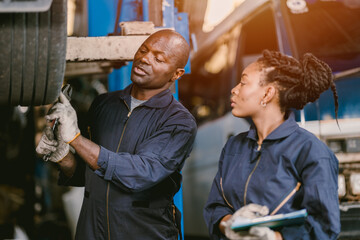 Auto garage worker Black African working together to fix service car vahicle wheel support together