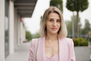 Close up portrait of young beautiful happy female worker looking at camera and smiling in cabinet.  woman entrepreneur in room at workplace, businesswoman, professional concept