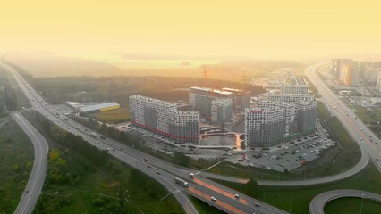 Fototapeta na wymiar Sunset over city, drone view of metropolis with new districts and highway with good interchanges. New comfortable areas of city. View from height above metropolis on hot days.