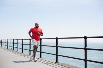 Mature black male jogging outdoors by the sea