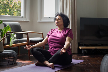 Mature black female practicing medication at home
