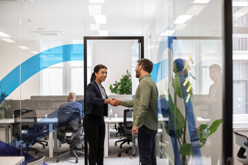 Businesspeople shaking hands at a job interview in a corporate office