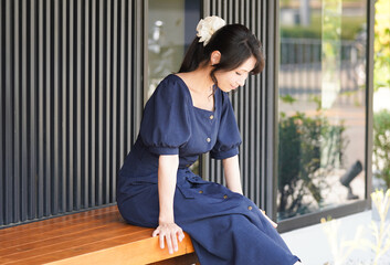 屋外で座っている女性＿うつむき