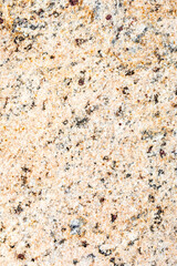 The texture of natural granite stone. The background of pinkish-beige stone interspersed with yellow, brown, gray and black tones. Copy Space