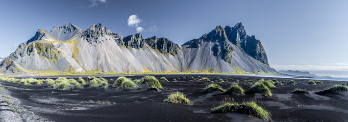 Mountain panorama with black sand and greens gras