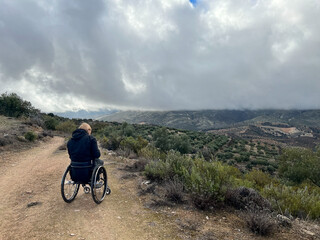 Woman in wheelchair looking at mountains in the country