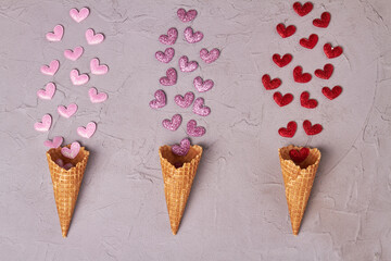 Three ice cream horn cones with sequin hearts. Valentines day or creative concept.