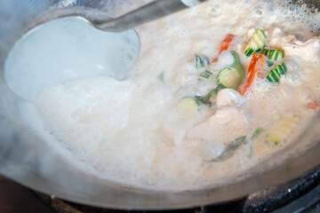 Close-up of Thai cooking looking directly into a steaming wok