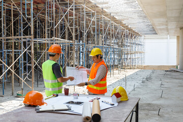 Construction concept of Engineer and Architect working at Construction Site with blue print