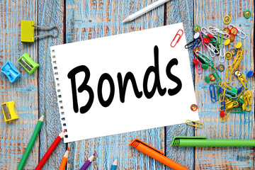 bright background. lots of bright stationery. text on notepad. BONDS