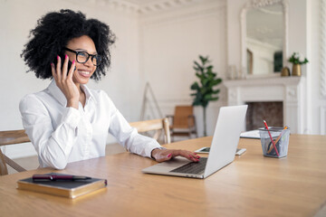 A female administrator with glasses in the office is working on a startup project using a laptop