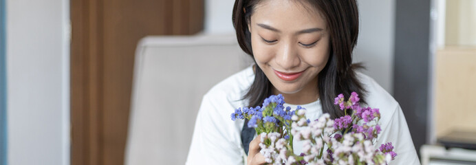 Bouquet, Asian woman puts a beautiful bouquet of colorful flowers in a vase to decorate the room,...
