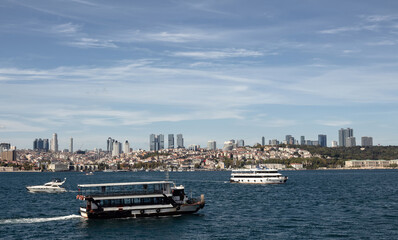 Fototapeta na wymiar View of tour boats on Bosphorus and European side of Istanbul. It is a sunny summer day.