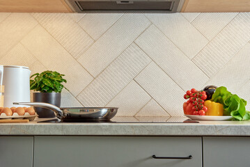 Modern kitchen appliance, Induction stove with steel frying pan, Front view of kitchen interior