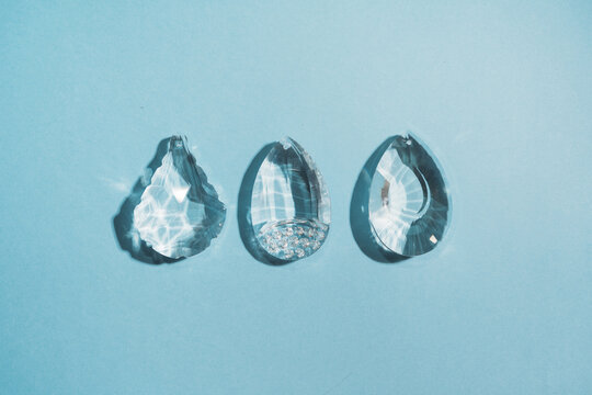 Three crystals with light refraction on blue minimal background 