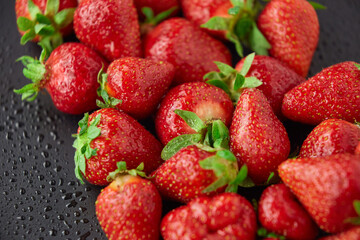 Strawberry on a black background with raindrops very fresh bright open diaphragm attractive advertising hunt buy in a hurry