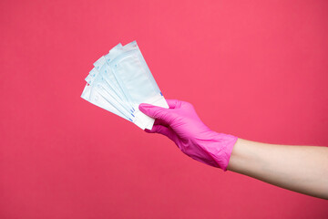 Hand holding sterilization envelopes for manicure in gloves