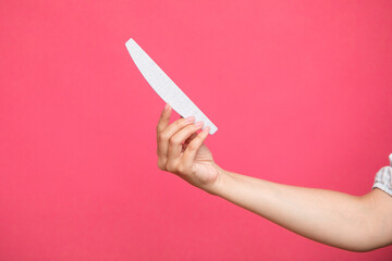 manicure and pedicure nail file in a hand isolated on pink background. cosmetic tool