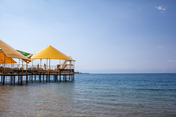 Swimming area or pier on the sea. A large pier with a roof, wooden planks and rusty stairs descending into the water. Bathing and resting place.