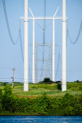 Hydro electric poles with wires in a field crossing a river