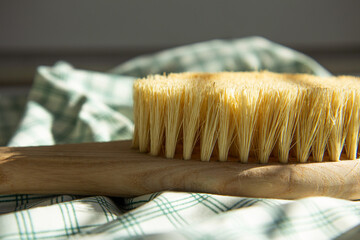 Dry natural bristle brush with wooden handle for anti cellulite massage. Close-up of massage brush...