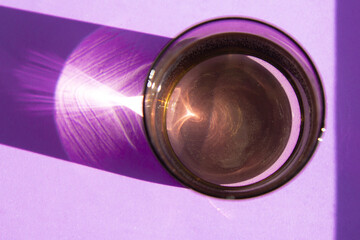 Glass of fresh water on violet background with copy space