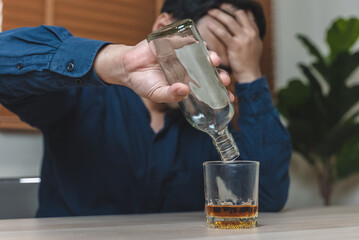 drunk man holding whiskey glass on the table