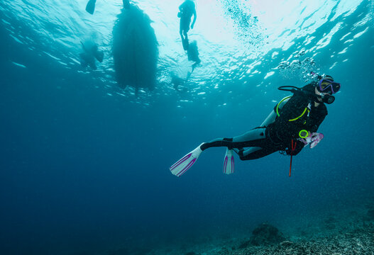 Diver emerging into the tropical waters of the Andaman Sea