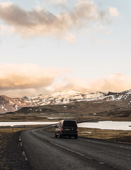 van on the road through the snowy mountains of Iceland
