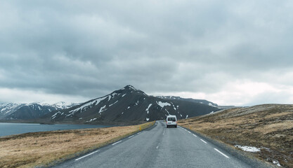 van on the road through the snowy mountains of Iceland
