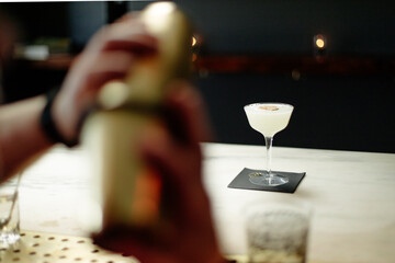 Ice cold cocktail sits on wooden white marble bar
