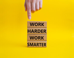 Work harder Work smarter symbol. Wooden blocks with words Work harder Work smarter. Beautiful yellow background. Businessman hand. Business concept. Copy space.