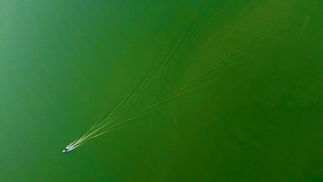 isolated speed boat running on lake water from top angle